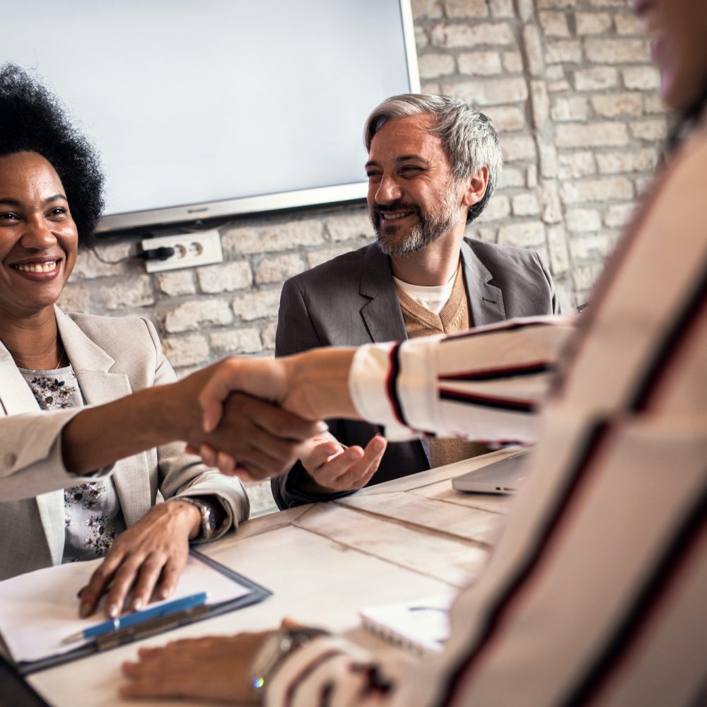 Business recruiters shakes hands with candidate during job interview.